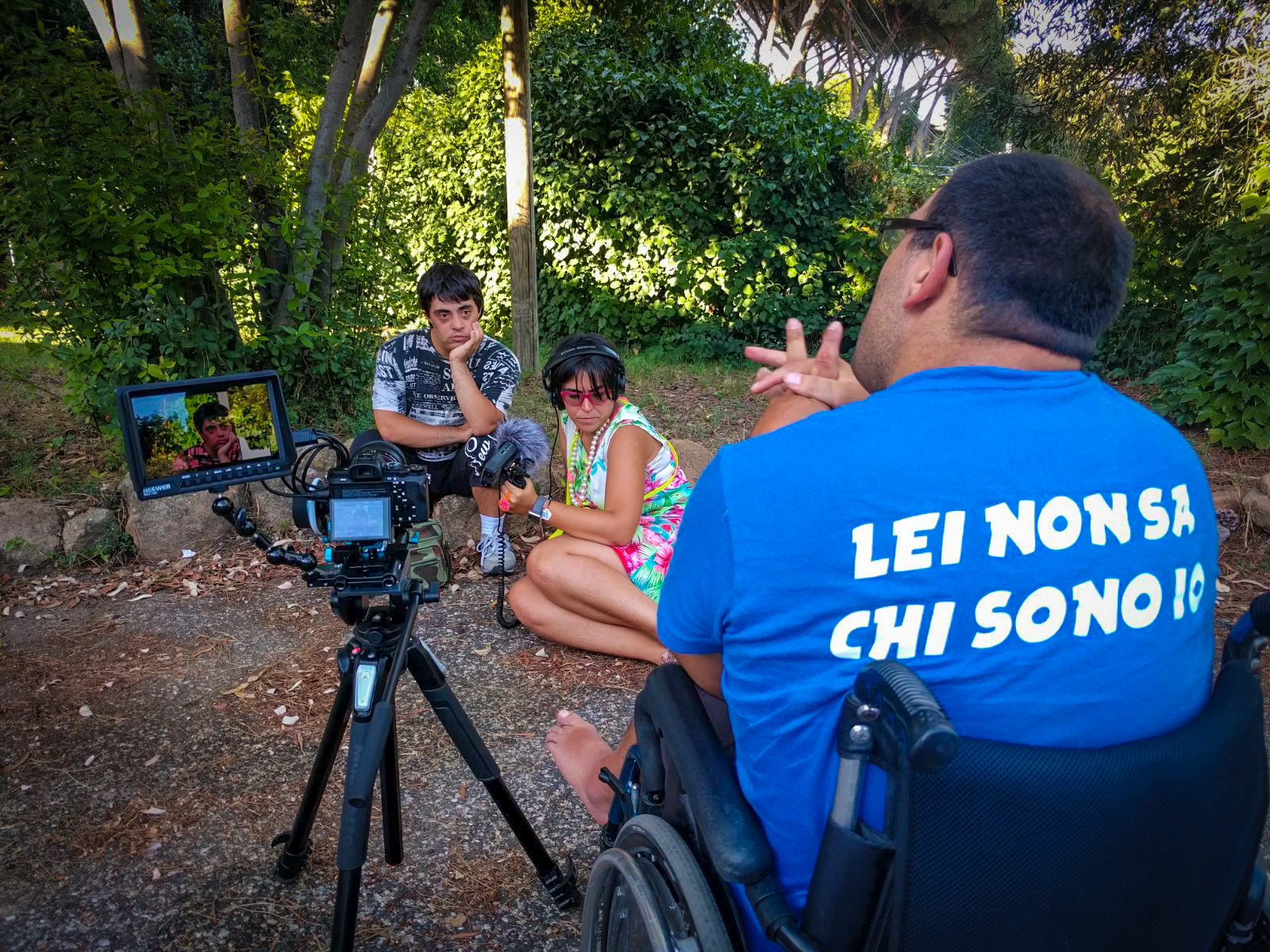 sulla sedia del regista, Luca indossa una maglietta con la scritta "Lei non sa chi sono io" mentre intervista Andrea